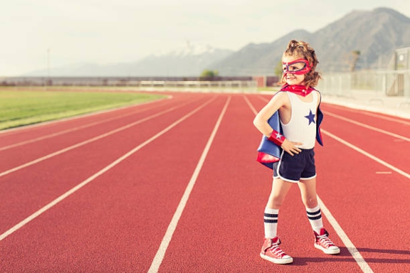 enfant super-héros sur piste d'athlétisme