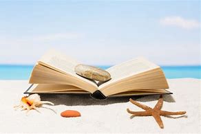 Un livre ouvert sur une plage. Il y a une étoile de mer près du livre et un galet gris posé sur les pages. 