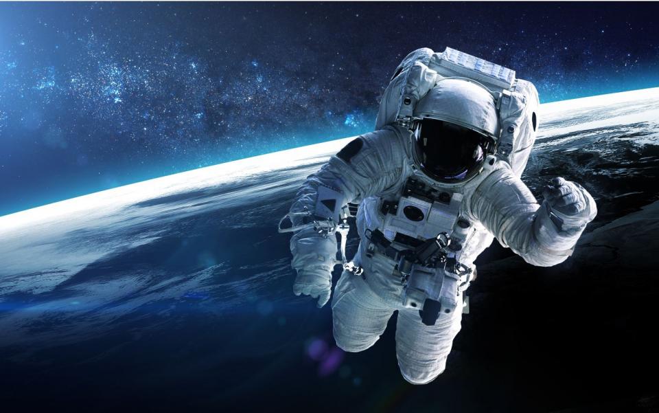 Photo en couleurs d'un astronaute en apesanteur dans l'espace 