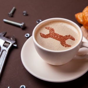 Tasse à café avec image de clef à molette dans la mousse de café