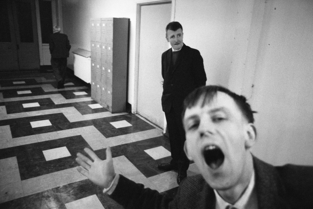 Photographie en noir et blanc de deux patients d'un hôpital psychiatriques dans un couloir