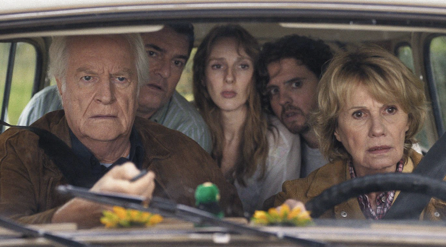 Cinq personnes dans une voiture : deux parents et leurs enfants adultes.