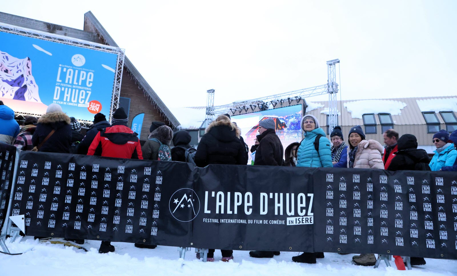 Des spectateurs font la queue avant d'entrer au Palais des Congrès, le sol est enneigé