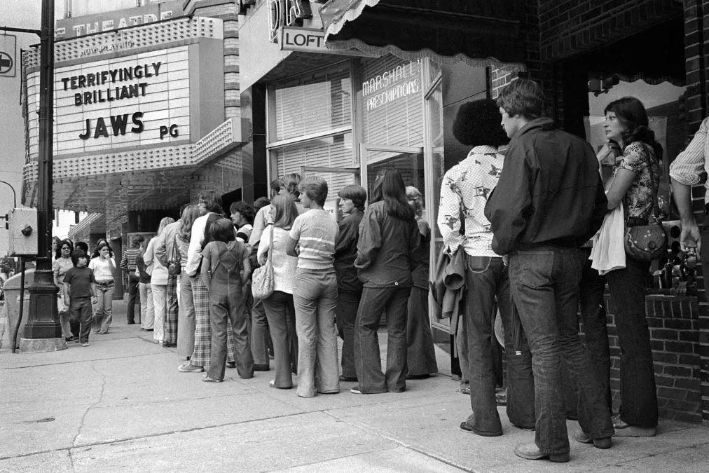Spectateurs qui font la queue devant un cinéma pour la sortie des Dents de la mer, USA 1975 