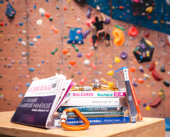 Pile de livres et jeux vidéo dans une salle d'escalade