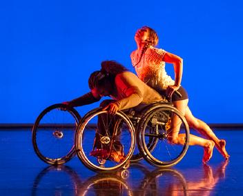 deux danseuses autour d'un fauteuil roulant