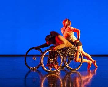 Deux danseuses autour d'un fauteuil roulant